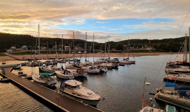 Plusieurs bateaux accostés au bord d'un quai dans un ciel de début de soirée