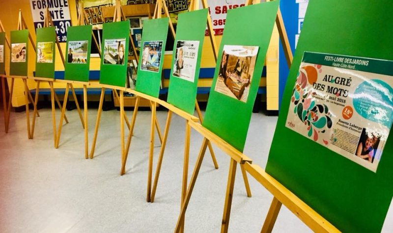 Une série de chevets de couleur bois placé en rang muni chacun de pancarte verte avec des affiches collés.