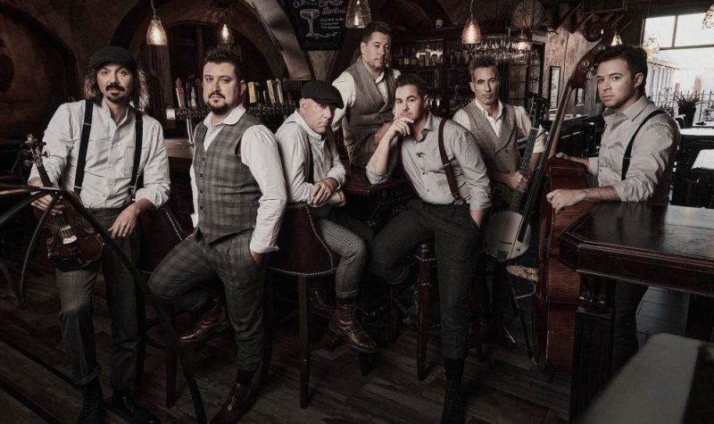 Sept hommes musiciens dans un bar.