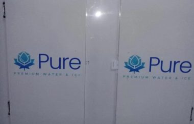 Deux grandes portes blanches sur lesquelles sont inscrites en gros « Pure » et en plus petit « Premium Water and Ice ».