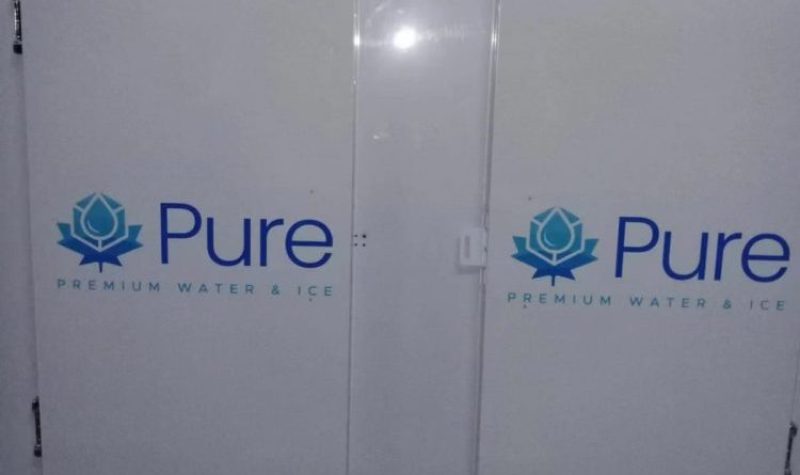 Deux grandes portes blanches sur lesquelles sont inscrites en gros « Pure » et en plus petit « Premium Water and Ice ».