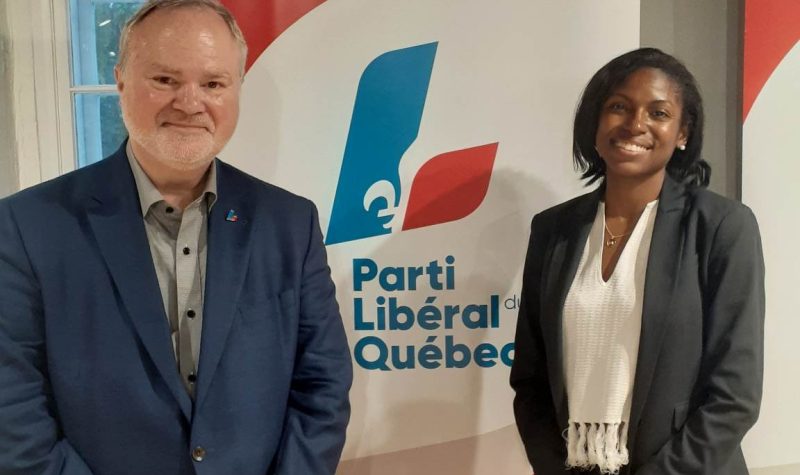 À gauche, André Pratte, vêtu de veston bleu. À droite, Madwa-Nika Cadet, vêtue d'un chandail blanc et d'un veston noir. Au milieu, une bannière arborant le logo du Parti libéral du Québec.