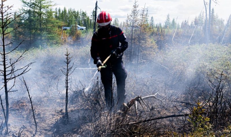 Un homme combattant la fumée avec un ensemble de protection et un masque