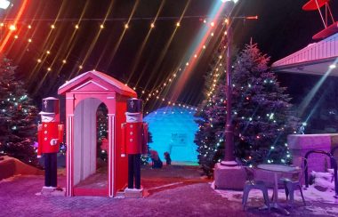 Des décorations de Noël à l'extérieur comprenant un gros sapin illuminé, un igloo gonflable géant et des soldats de casse-noisette géant