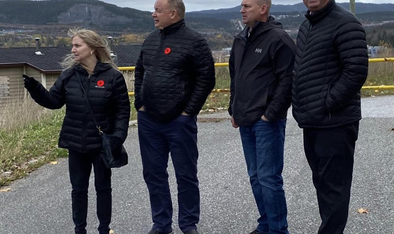 Immigration Minister Gerry Byrne (far right) meets with the Housing Minister and NLHC executives to talk about solutions to housing issues in Corner Brook. All four are wearing dark coats. It's a dark cloudy day in Corner Brook.