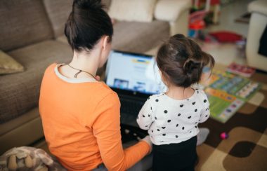 Mom using a computer to help teach her daughter