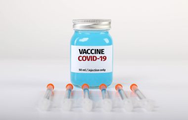 Syringes with bottle with COVID 19 vaccine on white background