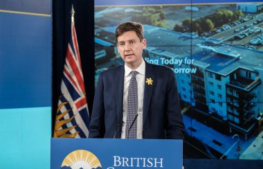 A man speaks behind a podium with British Columbia's government logo.