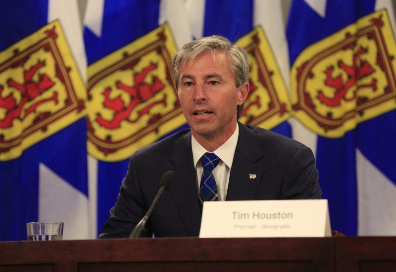 Tim Houston en conférence de presse devant des drapeaux de la Nouvelle-Écosse