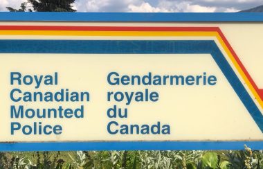 An RCMP sign close up. It is a sunny day in the background.