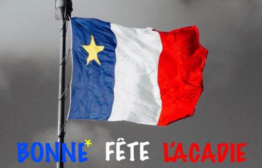 Un drapeau acadien avec lÉcriteau Bonne fête l'Acadie.