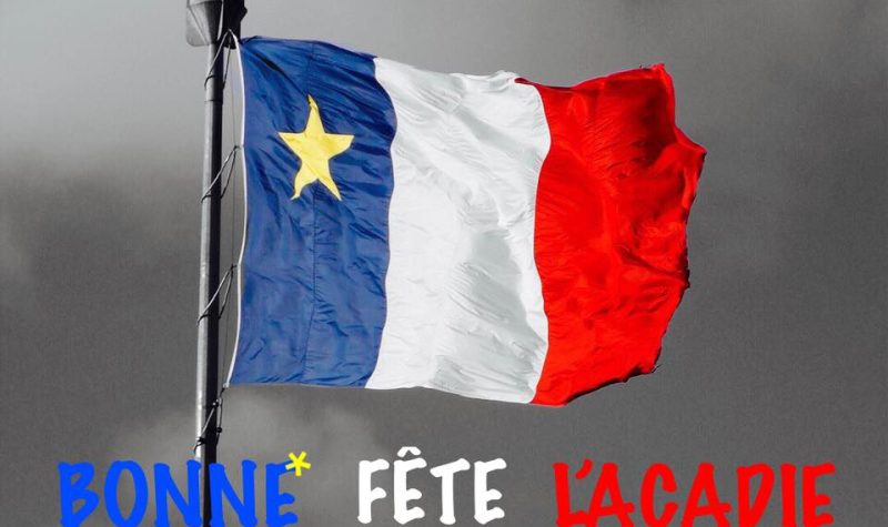 Un drapeau acadien avec lÉcriteau Bonne fête l'Acadie.