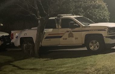 Two RCMP vehicles are seen at night pulled up outside of a residence in Campbell River during an investigation