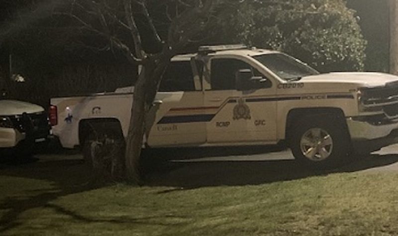 Two RCMP vehicles are seen at night pulled up outside of a residence in Campbell River during an investigation