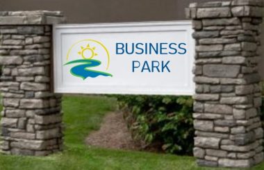 A brick-legged sign features Centre Wellington branding and the text on a white sign reads BUSINESS PARK.