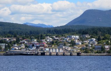 A city on a a seashore with mountains in the background