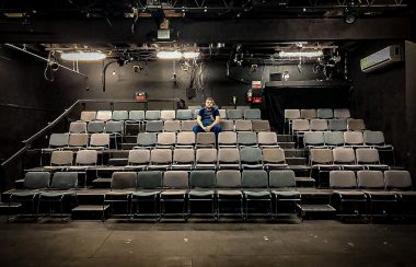 Matthew Downey, directeur technique du Bus Stop Theater, assis dans la salle vide du théâtre. Photo : Bus Stop Theater