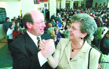 une femme et un homme sourient et se serrent la main