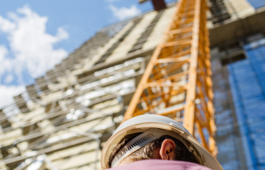 Un hombre de espaldas mirando un edificio en construcción. Foto: Canva.com