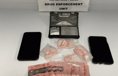 A police photo of illicit drugs, cell phones, Canadian Currency, and a drug scale