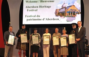 des personnes devant un panneau écrit dessus Festival du patrimoine d'Aberdeen