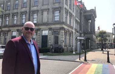 Showing Cobourg councillor by crosswalk outside town hall