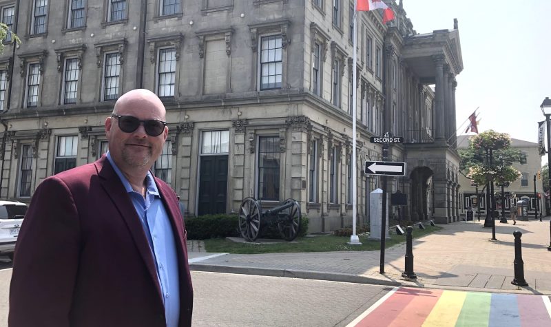 Showing Cobourg councillor by crosswalk outside town hall