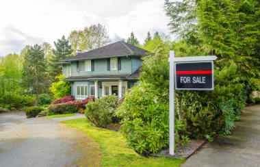 House For Sale Real Estate Sign in Front of a House