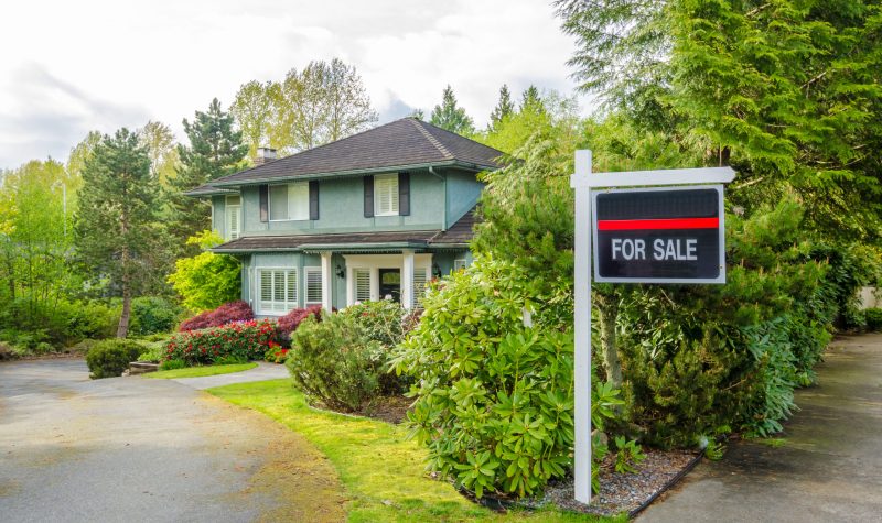 House For Sale Real Estate Sign in Front of a House