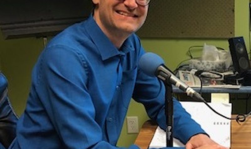 Hydro Quebec representative Alain Paquette sits in CHIP 101.9's studios wearing a blue collared shirt.