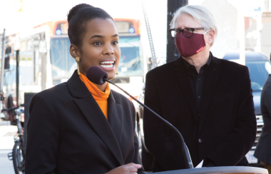 A photo of Alicia Hall speaking at a podium in Toronto.
