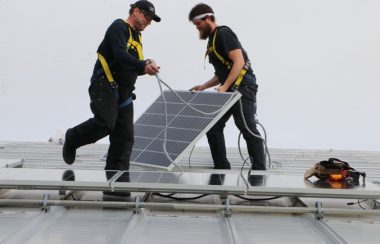 Workers installing rooftop solar panels. Photo: amherst.ca