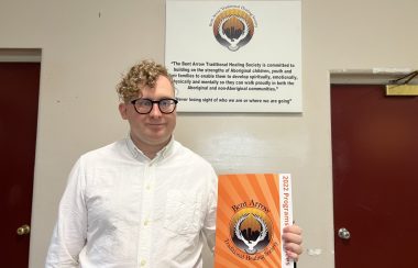 Image shows Vernon Boldick holding a pamphlet for Bent Arrow