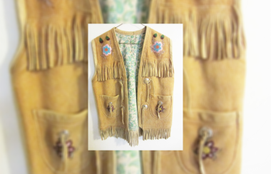 A beaded vest with fringe. There is a small photo of the vet on top of the main photo.