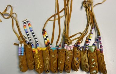 11 small leather bundles with leather strings with some beaded, 2x3' sachels