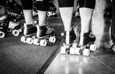 A line of legs stand in roller skates for the Bulkley Valley Roller Derby Fresh Meat Program