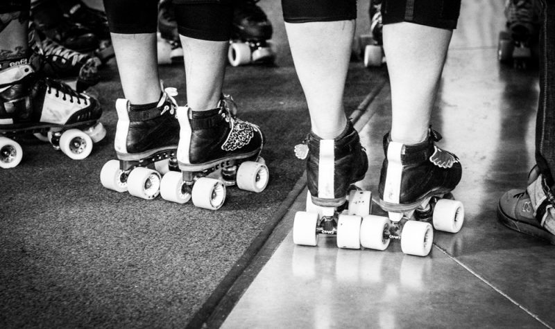 A line of legs stand in roller skates for the Bulkley Valley Roller Derby Fresh Meat Program