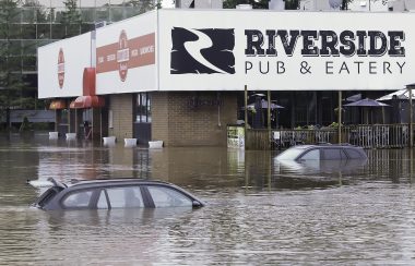 Flood waters submerge cars up to their windows in the parking lot of a Bedford restaurant