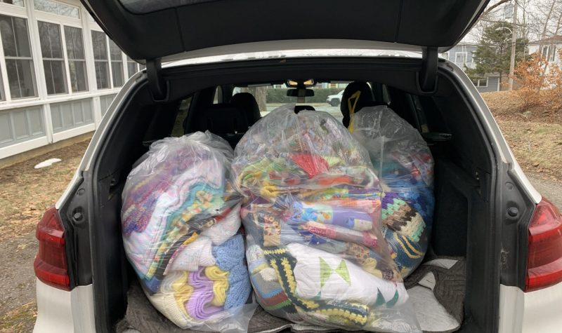 Colourful blankets bagged and loaded in the back of a vehicle