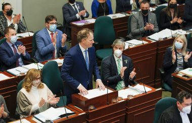 A man stands in behind a desk in the Nova Scotia legislature