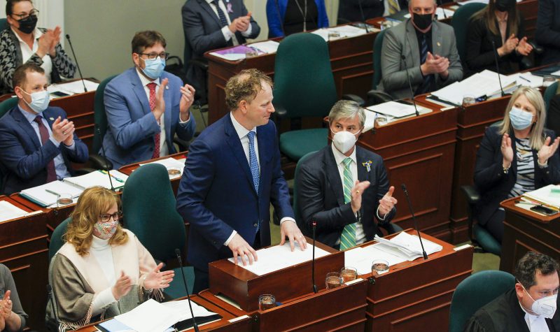 A man stands in behind a desk in the Nova Scotia legislature