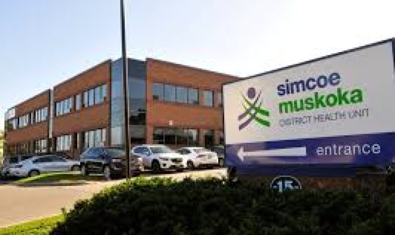 Logo du bureau de santé de Simcoe Muskoka, l'édifice avec des voitures dans le stationnement