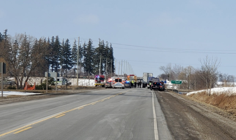 Emergency crews are seen at a distance on Highway 7 on a sunny day