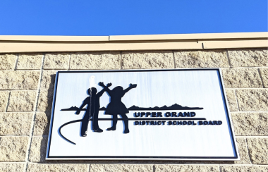 The Upper Grand District School Board logo on a sign, attached to a building