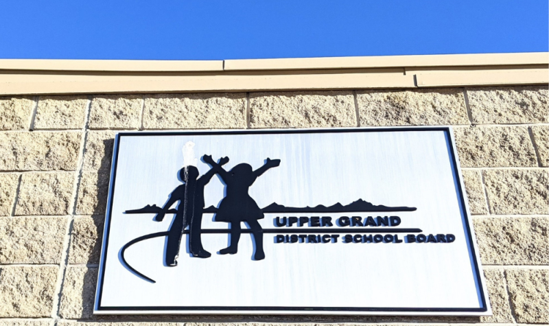 The Upper Grand District School Board logo on a sign, attached to a building