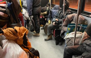 People rest inside a TTC bus late at night