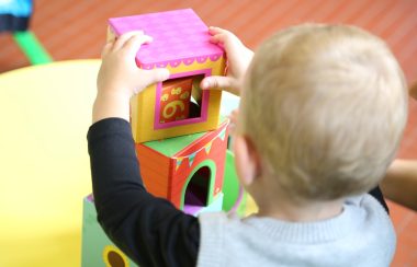 Un enfant joue avec des cubes en bois.