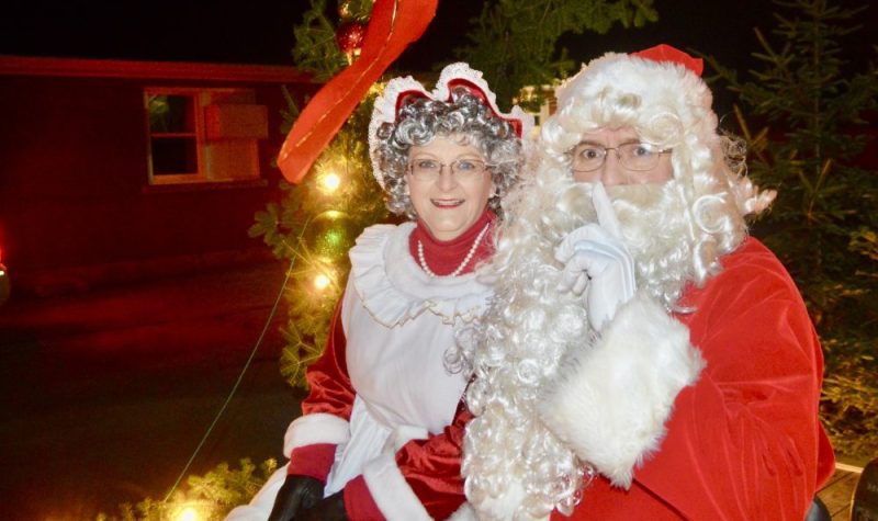 Un homme et une femme déguisés en Père Noël et Mère Noël.