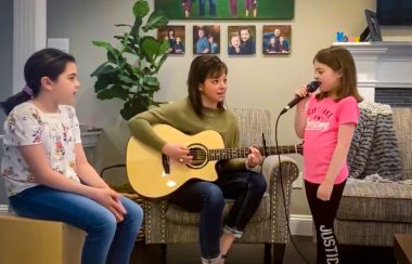 Trois jeunes filles jouent de la musique dans un salon