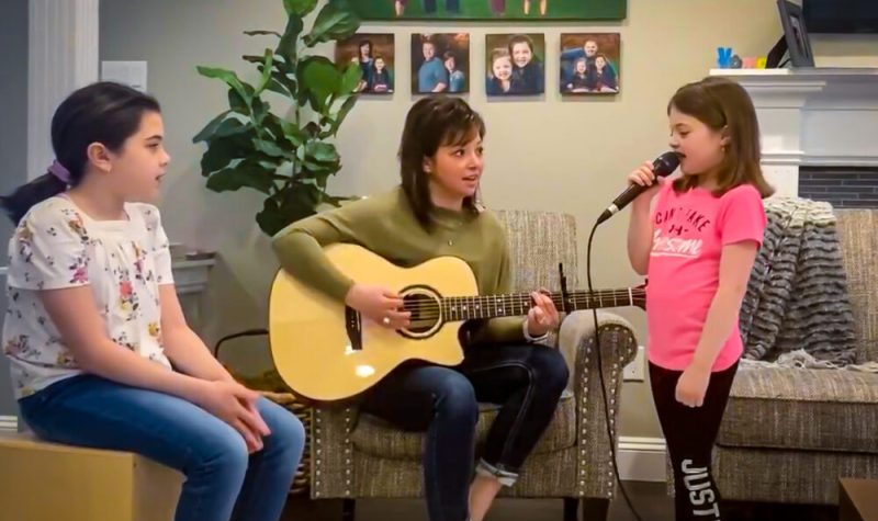Trois jeunes filles jouent de la musique dans un salon